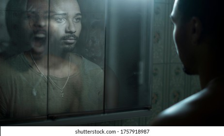 man in front of a mirror observing his deepest fears