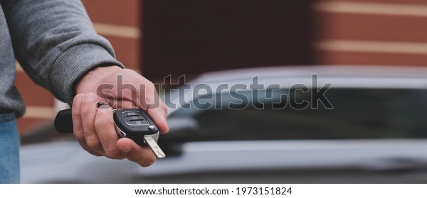 Man in front
of the new car and holding keys. Salesman is carrying the car keys
delivered to the customer at the showroom .  Rent, credit,
insurance, car purchase. Copy space.
Banner.