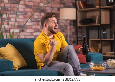 A man in front of the television watches a game of sports sitting on the couch. Concept of sports, relaxation, fanfare, betting. - Shutterstock ID 2188627775