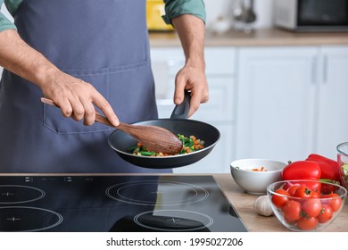 Man Frying Vegetables In Kitchen, Closeup