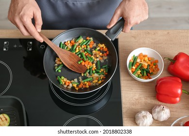 Man Frying Vegetables In Kitchen, Closeup