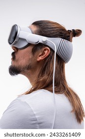 A man fully engaged in a spatial computing experience with a AR headset, reaching out to navigate the immersive digital environment. White background