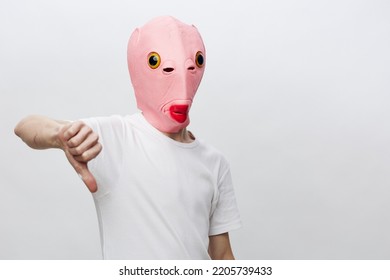 a man in a funny pink mask gesturing shows a sign of disgust
