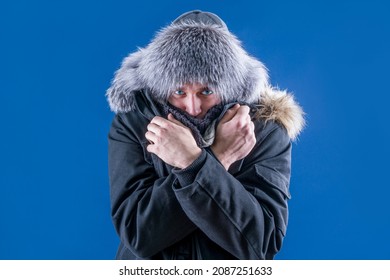 A Man In A Fur Hat And Warm Clothes Crossed His Arms To Keep Warm. Freeze In Winter. Snowfall. Winter.