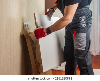 a man furniture assembler unpacks boxes with furniture boards for assembly. copy space. - Shutterstock ID 2161820991