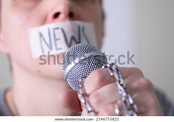 A\
man gags his mouth with duct tape saying news trying to speak into\
a microphone. The concept of World Press Freedom\
Day.