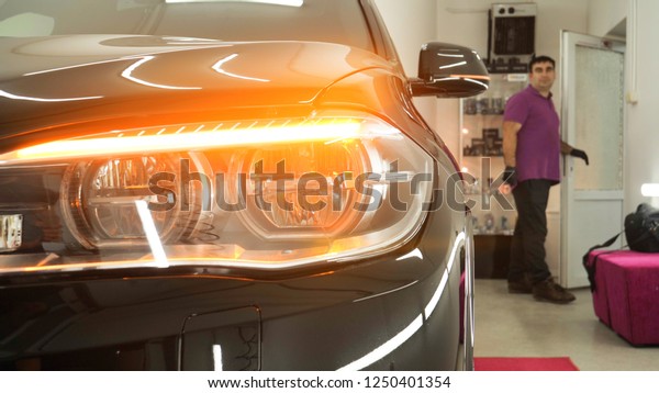 A man in the garage\
(car service) Checks the car alarm and then goes off (comes in)\
turning off (turning on) the lights behind him. Concept of: Auto\
garage, Security.