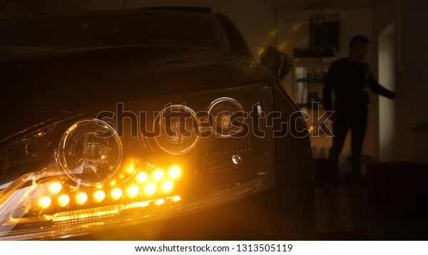 A man in the
garage (car service) Checks the car alarm and then goes off (comes
in) turning off (turning on) the lights behind him. Concept of:
Auto garage, Security.	
