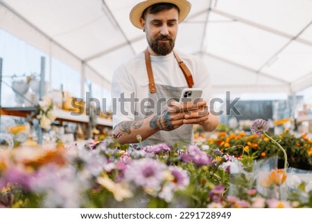 Man gardener working wit mobile phone. E-commerce, online order concept.