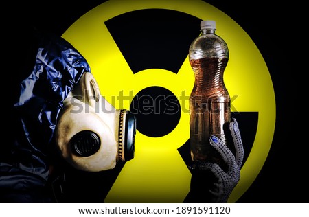 Man in the gas mask holding plastic bottle with dirty water. Radiation influence. Environmental pollution. Chernobyl concept. Dangerous nuclear power. Ecological disaster.