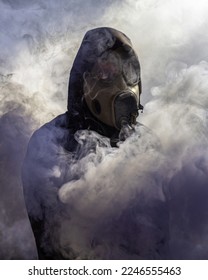 Un hombre con máscara de gas en el humo. Detalles del espeluznante humo colorido. Máscara de gas czechoslovakiana antigua M-10(M). 