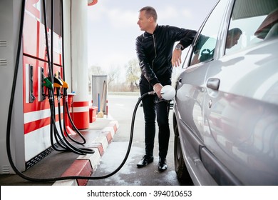 Man At Gas Station Filling Up Her Car With Petrol