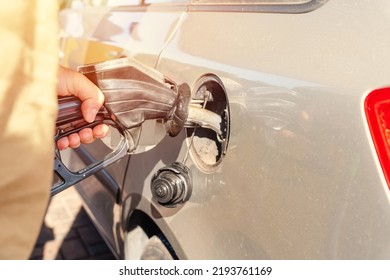 A man at the gas station filling the tank of his car with diesel to the top level before a long journey as fuel prices is going up - Shutterstock ID 2193761169