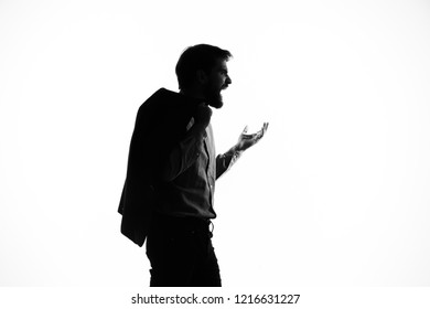 man gesticulates with a jacket over his shoulder                     