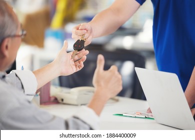 Man Get He Car Keys Back At The Counter Of The Tire And Car Service Workshop From The Mechanical Employee Of The Succesfull Service