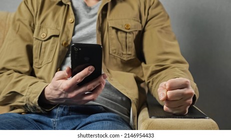 Man gets angry after losing lottery hitting armrest with fist sitting in armchair against grey wall. Player lost money in mobile phone app at home closeup - Shutterstock ID 2146954433