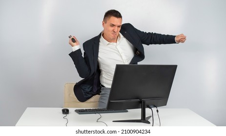 The Man Gets Angry And Smashes The Monitor With A Hammer. An Office Worker In A Rage Breaks The Computer. 