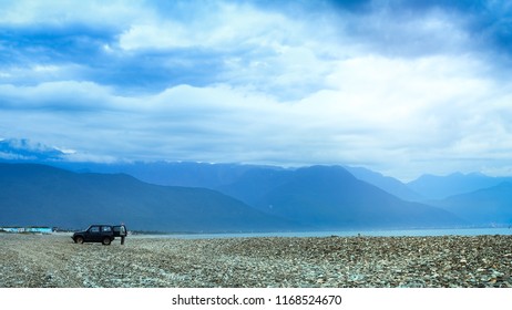 A Man Gets Off His Car And Enjoy The Amazing Taiwanese Beach. There Are Mountain Ranges, Pebble Beach And Ocean. This Image Feels Peaceful, Quiet, Isolated And Secluded. It Is Suitable For Background.