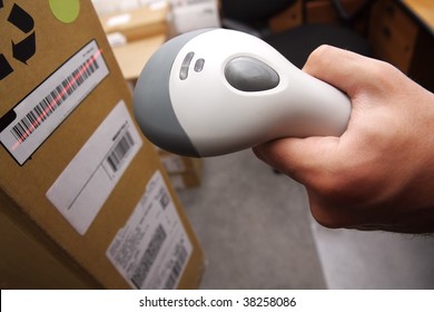 A man gets on the hip scaner in operations directed on printed barcode. Warehouse scene. Shallow DOF!
