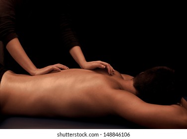 Man Getting A Back Massage At Spa, Low Key Lighting With Black Background