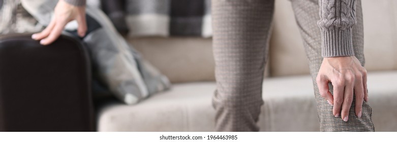 Man Getting Up From Couch And Holding On To Sore Knee Closeup