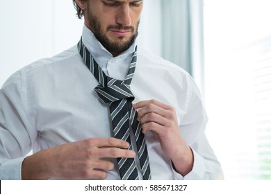 Man Getting Dressed In Bedroom At Home