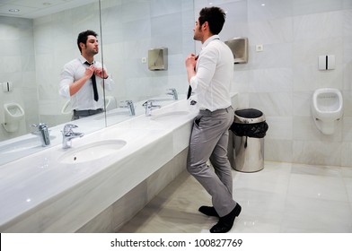 Man Getting Dressed In A Public Restroom With Mirror