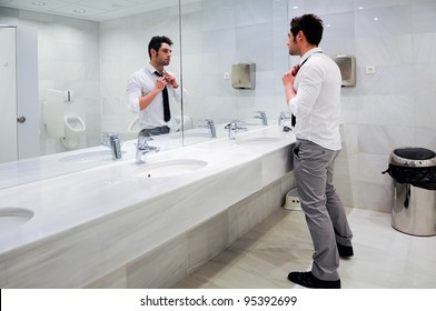 Man Getting Dressed In A Public Restroom With Mirror