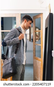 Man Getting Dressed, Standing In Front Of Mirror At Home