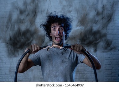 Man getting electric shock connecting broken electrical cables at home. Husband having domestic accident being electrocuted with dirty burnt face and crazy expression. Electricity DIY repairs danger.