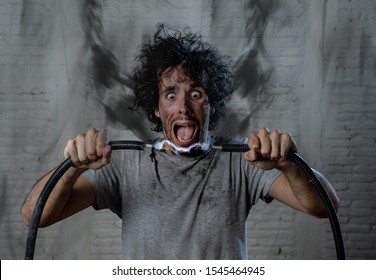 Man Getting Electric Shock Connecting Broken Electrical Cables At Home. Husband Having Domestic Accident Being Electrocuted With Dirty Burnt Face And Crazy Expression. Electricity DIY Repairs Danger.