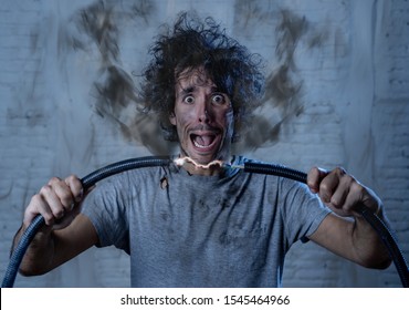 Man getting electric shock connecting broken electrical cables at home. Husband having domestic accident being electrocuted with dirty burnt face and crazy expression. Electricity DIY repairs danger.