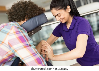 Man Getting Mobile Chair Massage By Woman In Office