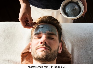 Man getting a mud mask at a spa