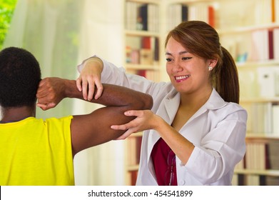 Man getting physical arm treatment from physio therapist, her hands working on his shoulder and elbow, medical concept