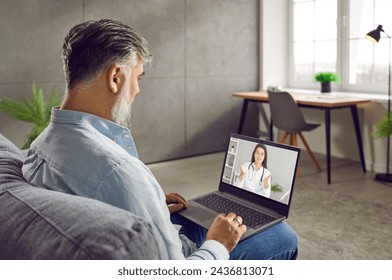 Man getting a professional medical consultation from an online doctor. Senior man sitting on the sofa at home, using his laptop computer and talking to a remote physician from a telemedicine clinic - Powered by Shutterstock