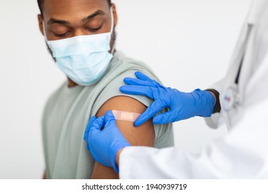 Man Getting Vaccinated Against Covid-19, Doctor Applying Plaster, White Background - Powered by Shutterstock