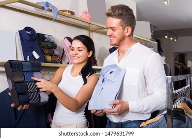 Man And Girl Chousing Shirt And Necktie At Clothing Shop