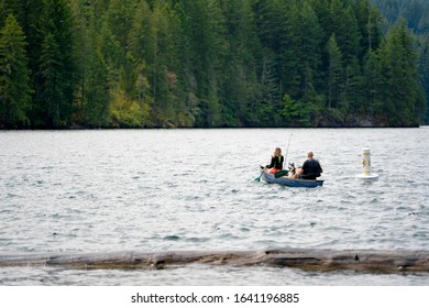 Man and girl - father and daughter in life jackets with family friend husky dog rowing fishing in the kayak boat on troubled Merwin Lake breaking the coastal breakwater having an active healthy rest - Powered by Shutterstock