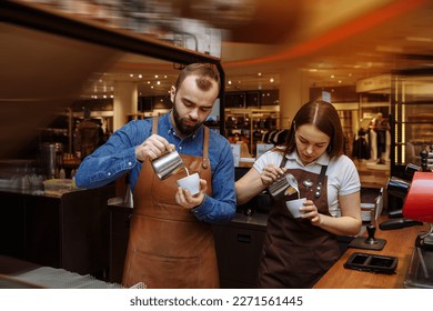 A man and a girl make coffee at a coffee machine in a coffee shop - Powered by Shutterstock