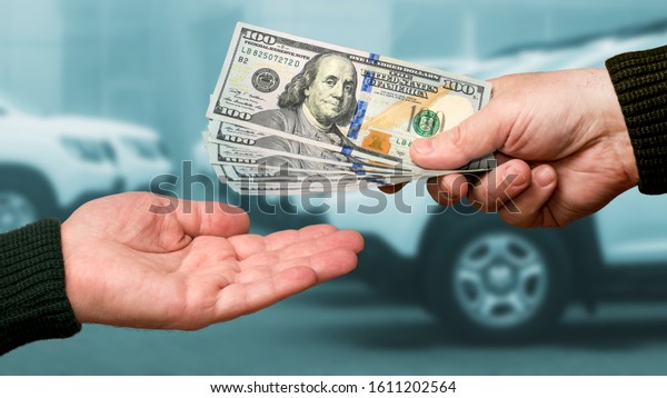 A man gives another man money for a car.\
Payment for the purchase or repair of a\
car