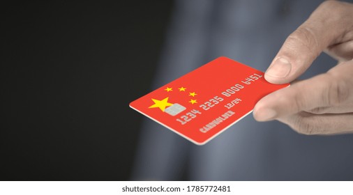 Man Gives Plastic Bank Card With Printed Flag Of China. Fictional Numbers