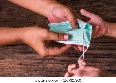 Man Gives Surgical Mask To Kid. Concept Of Inviting People To Donate Surgical Face Masks During Coronavirus Or COVID-19 Pandemic .