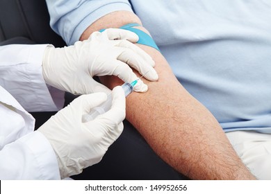 Man Giving Blood Donation With Syringe In His Arm