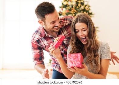 Man giving a Christmas present to his girlfriend - Shutterstock ID 488792596
