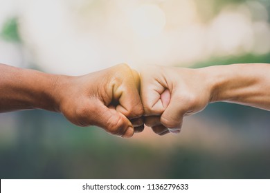 Man Giving Fist Bump In Nature Background. Power Of Teamwork Concept. Vintage Tone