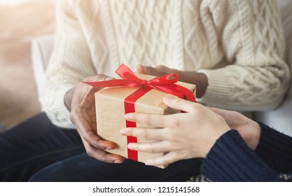 Man giving her wife a gift at home while celebrating New Year, closeup