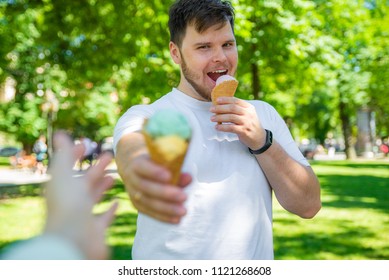 Man Giving Ice Cream In Hot Sunny Day In City Park. First Person Point Of View Reach Out Hand