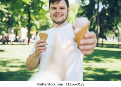 Man Giving Ice Cream In Hot Sunny Day In City Park. First Person Point Of View Reach Out Hand