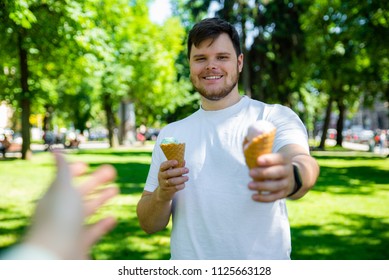 Man Giving Ice Cream In Hot Sunny Day In City Park. First Person Point Of View Reach Out Hand